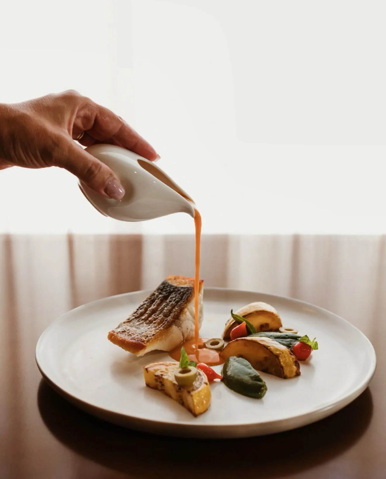 Um prato do Mesa 15 a receber o último toque de molho, servido à mesa